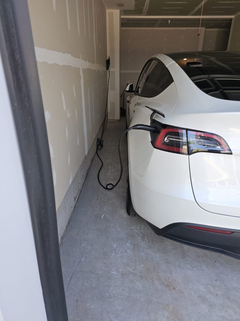 A white electric car plugged into the charger.
